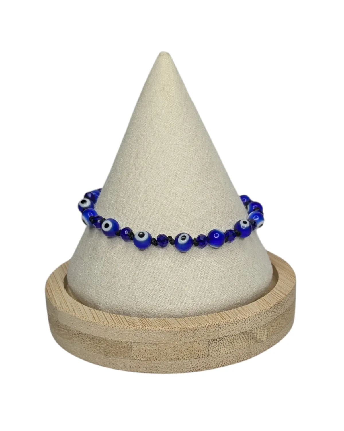 Blue evil-eye beaded bracelet displayed on a cream bracelet stand with a wood base.